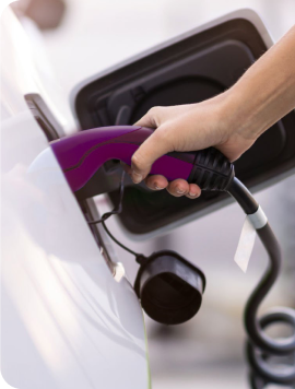 une personne qui recharge sa voiture sur une borne électrique